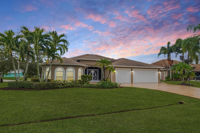 view of front of house with a yard and a garage