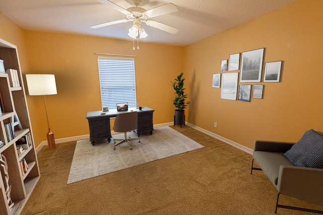 carpeted office space with ceiling fan