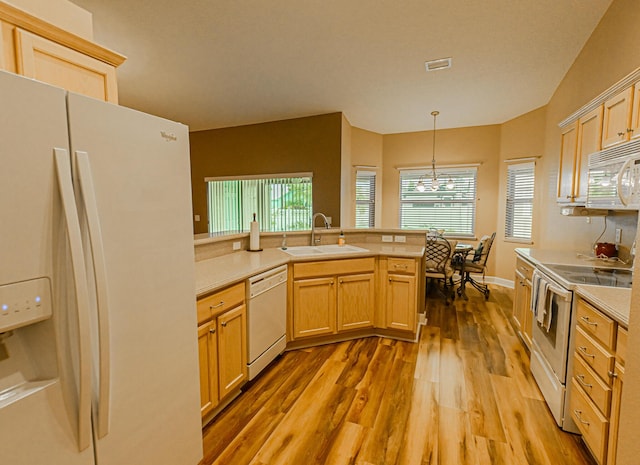 kitchen featuring white appliances, decorative light fixtures, light brown cabinetry, and sink