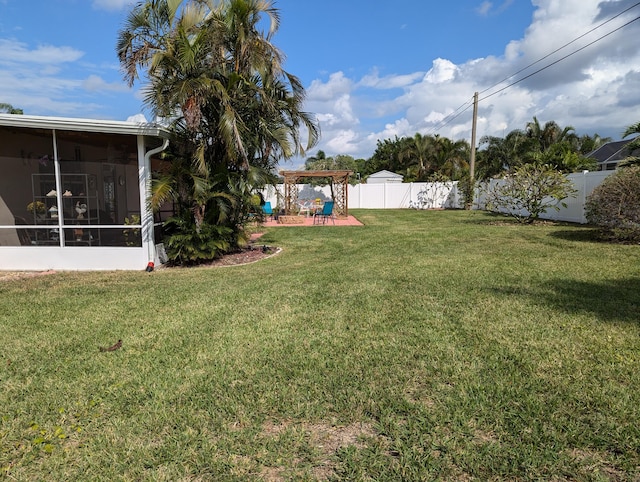 view of yard featuring a pergola, a patio area, and a sunroom