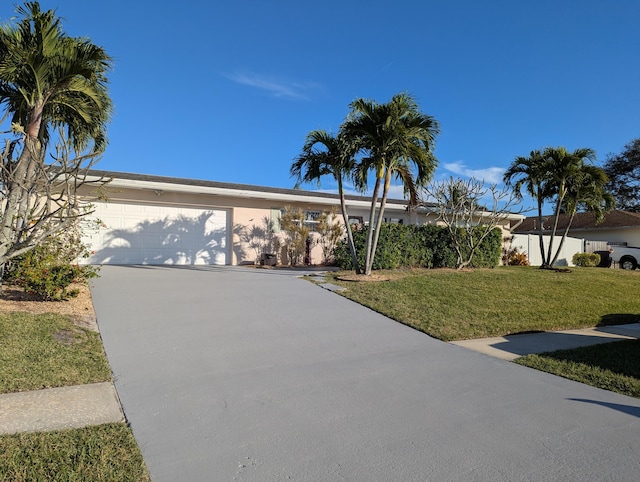 single story home featuring a garage and a front lawn