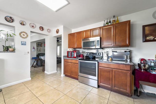 kitchen with decorative backsplash, light tile patterned flooring, ceiling fan, and appliances with stainless steel finishes