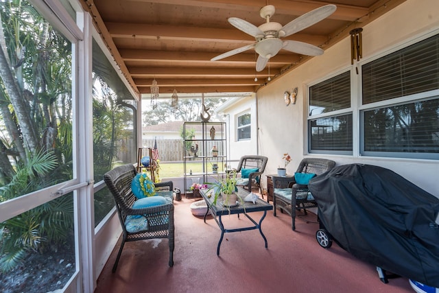 sunroom featuring beam ceiling and ceiling fan