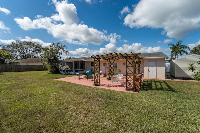 back of property featuring a storage unit, a pergola, a patio area, and a lawn