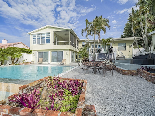 view of pool featuring ceiling fan, a sunroom, and a patio