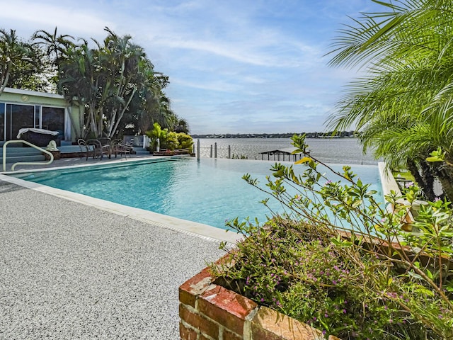 view of pool featuring a patio area and a water view