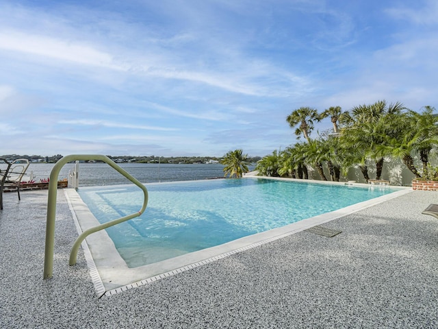 view of pool featuring a water view and a patio area