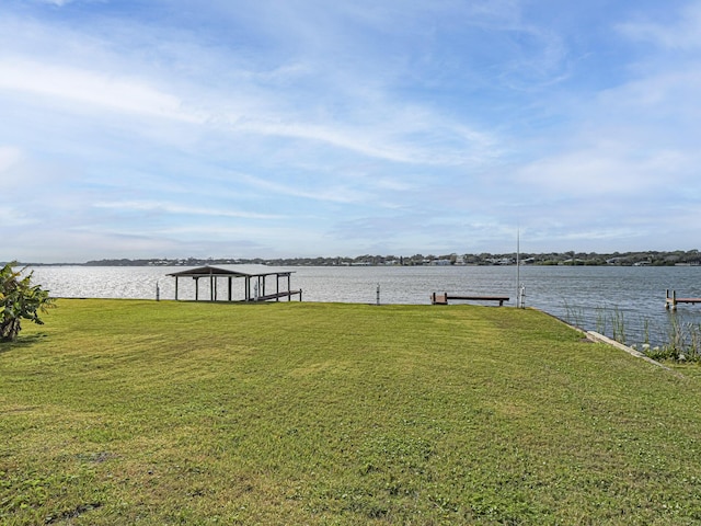 view of yard with a water view and a boat dock