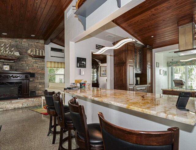 kitchen featuring lofted ceiling with beams, wooden ceiling, a fireplace, and light stone countertops