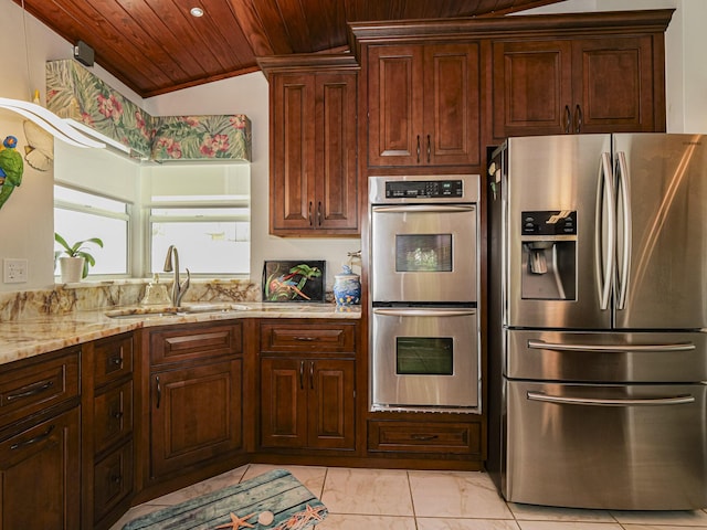 kitchen with lofted ceiling, wood ceiling, light stone counters, stainless steel appliances, and a sink