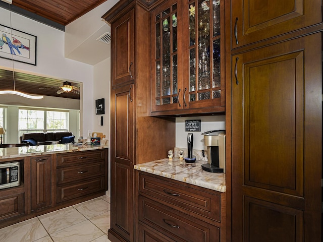 bar with marble finish floor, stainless steel microwave, ceiling fan, and visible vents