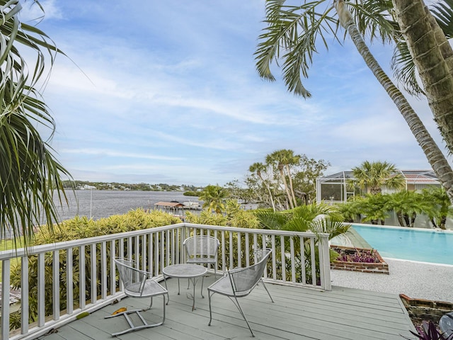 wooden terrace with a water view and glass enclosure