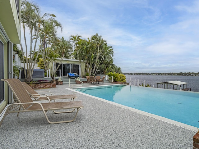 view of swimming pool featuring a patio and a water view