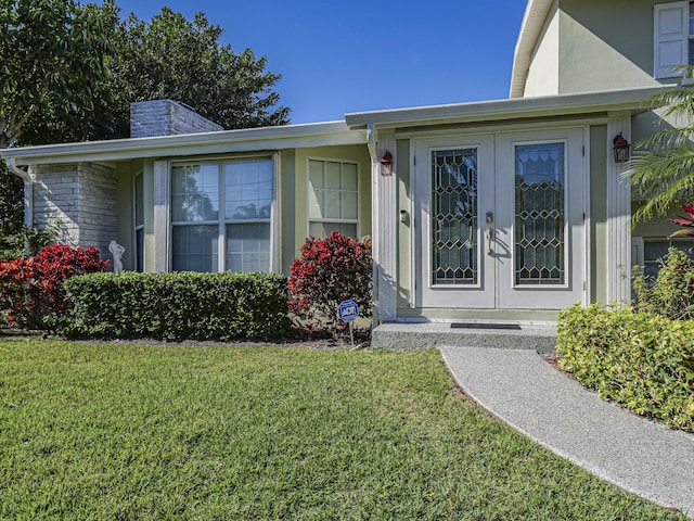 entrance to property with french doors and a yard