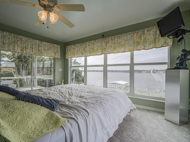 bedroom featuring a water view, ceiling fan, and carpet floors