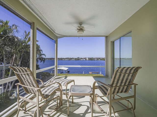 sunroom featuring a wealth of natural light, a water view, and ceiling fan