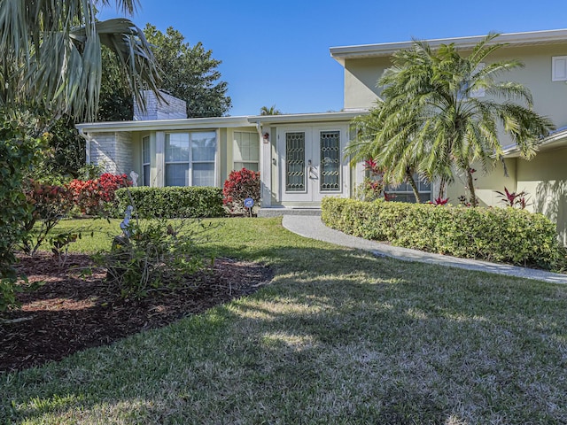 view of front of home featuring a front yard and french doors