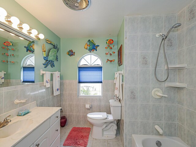 bathroom with vanity, tile patterned floors, toilet, and tile walls