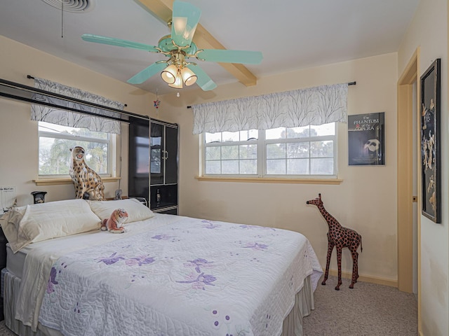 carpeted bedroom featuring multiple windows, beam ceiling, and ceiling fan