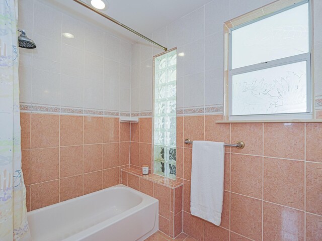 bathroom with vanity, tile walls, and a shower