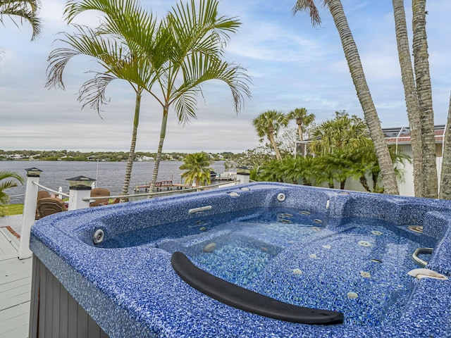 view of swimming pool with a water view and a hot tub