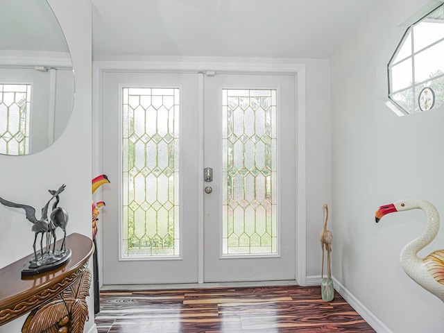 foyer featuring baseboards, wood finished floors, and french doors