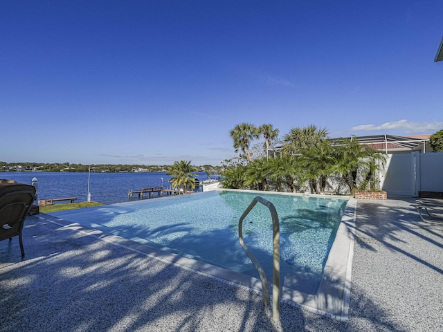 view of pool featuring an infinity pool, a water view, and fence