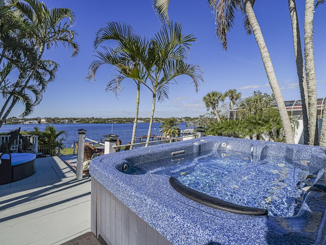 exterior space with a water view and a hot tub