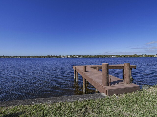 dock area featuring a lawn and a water view