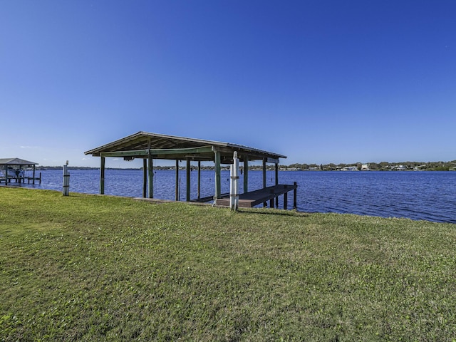 view of dock featuring a lawn and a water view