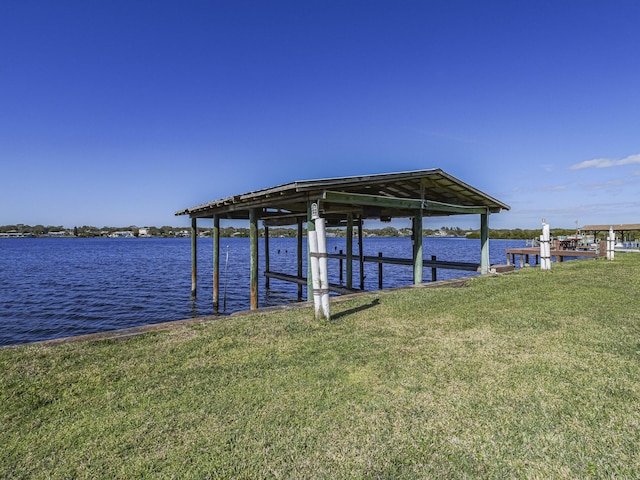 dock area with a water view and a lawn