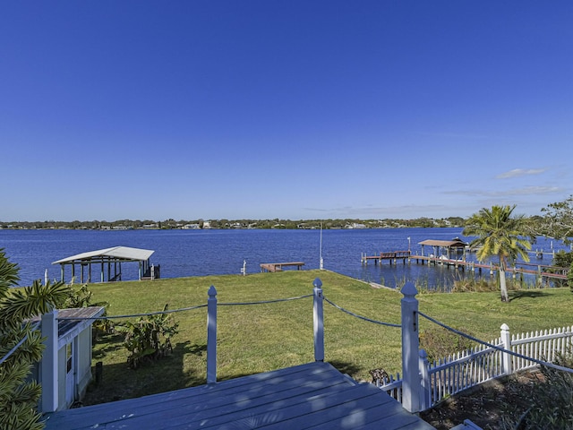 exterior space featuring a water view, a boat dock, and a lawn