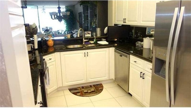 kitchen featuring light tile patterned floors, appliances with stainless steel finishes, white cabinetry, and sink