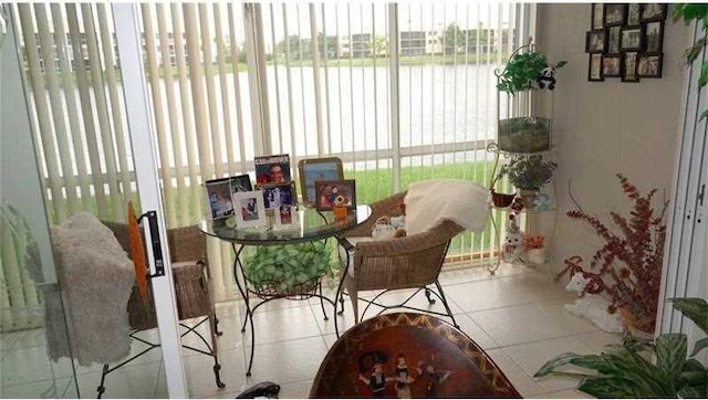 sunroom featuring a water view