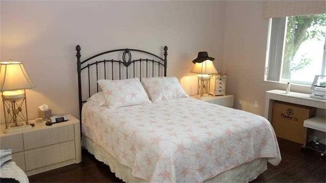 bedroom with dark wood-type flooring and multiple windows