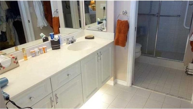 bathroom with walk in shower, vanity, and tile patterned flooring