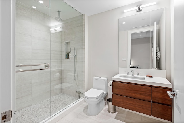 bathroom featuring tile patterned floors, toilet, walk in shower, and vanity