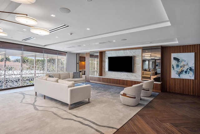 living room with floor to ceiling windows, parquet flooring, and a raised ceiling