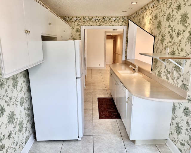 kitchen featuring white cabinetry, white appliances, light tile patterned flooring, and sink