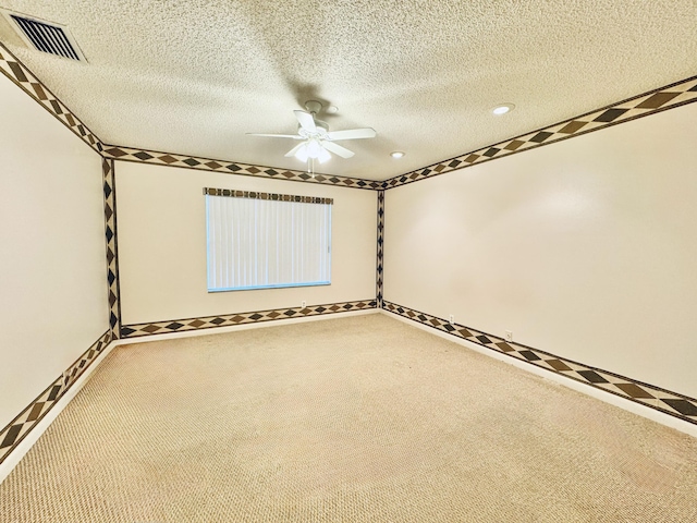 empty room with ceiling fan, carpet, and a textured ceiling