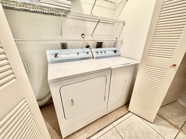 clothes washing area featuring washer and dryer and light tile patterned floors