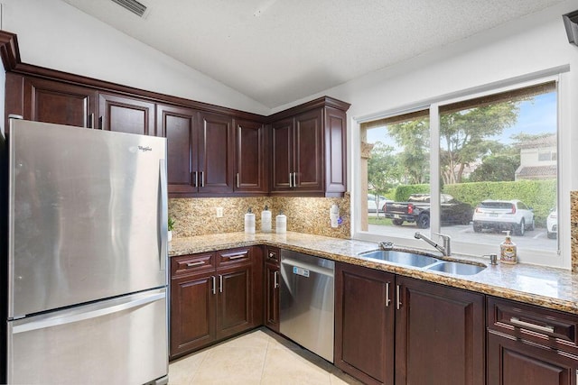 kitchen featuring lofted ceiling, tasteful backsplash, sink, stainless steel appliances, and light tile patterned flooring