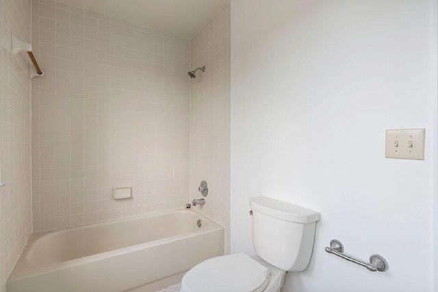 bathroom featuring toilet and tiled shower / bath combo