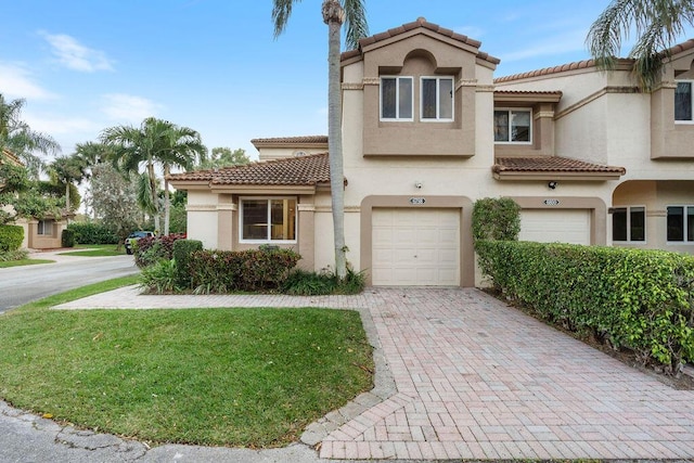 mediterranean / spanish-style home featuring a garage and a front yard