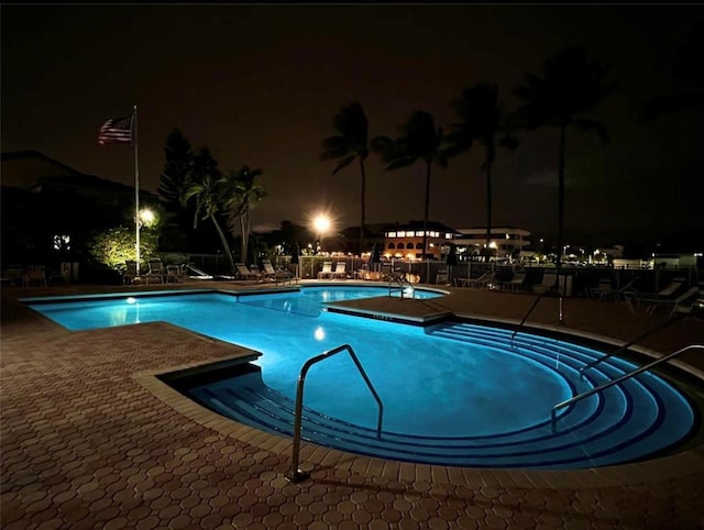 pool at night with a patio area