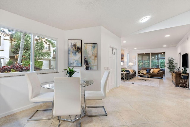 tiled dining space featuring vaulted ceiling