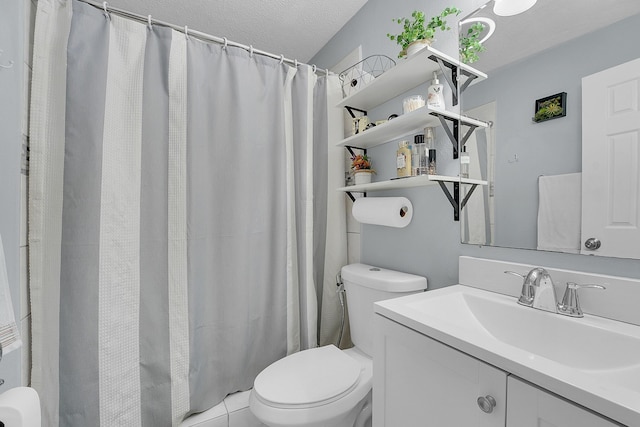 bathroom with toilet, vanity, and a textured ceiling