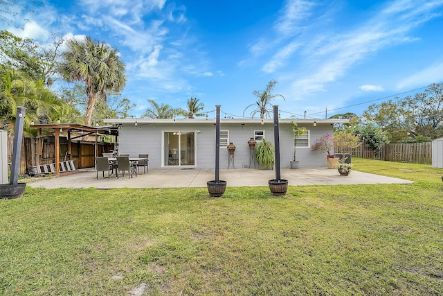 rear view of property with a lawn and a patio