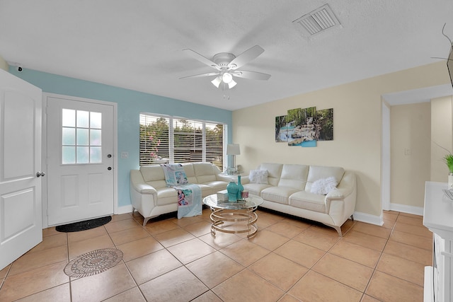 tiled living room featuring ceiling fan and a textured ceiling