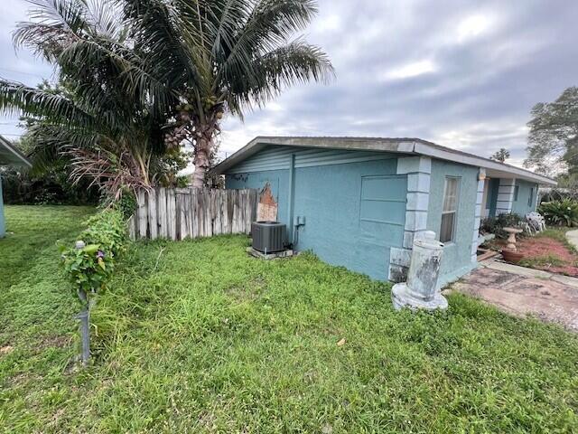 view of property exterior featuring central AC unit and a yard